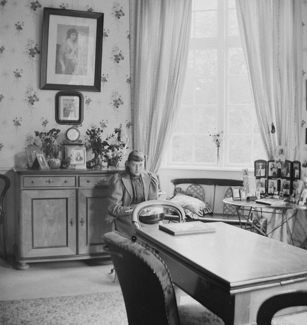 Portrait of an elderly Danish grandmother knitting wool by a window
