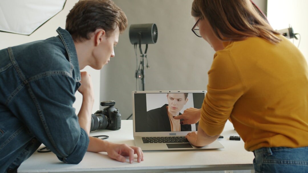 Photographer reviewing documentary photographs on a laptop in a studio